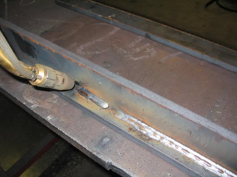 Cordon de soudure régulier le long d'un angle entre deux tôles d'acier, avec la buse de la torche à gauche